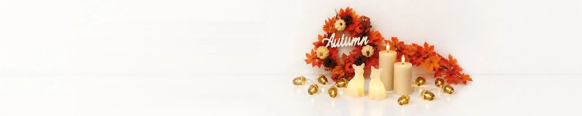 Couronne d'automne en feuilles d'érable, citrouilles, bougies et guirlande lumineuse avec glands