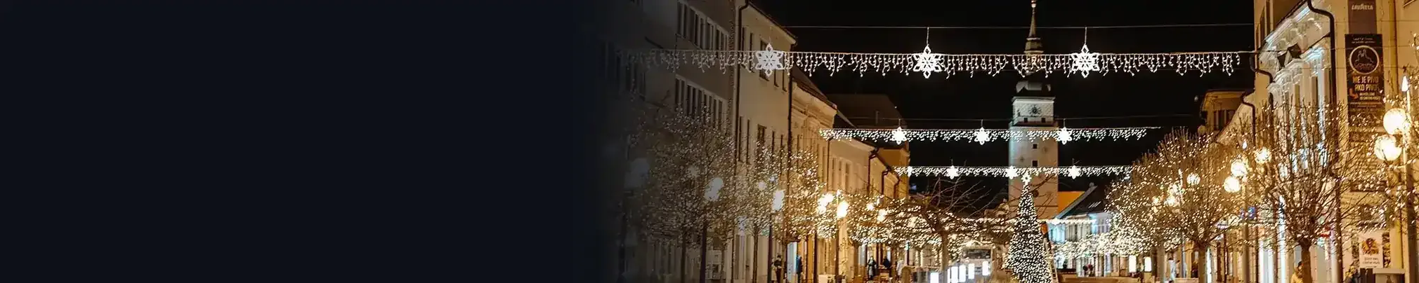 Rue de nuit avec illuminations de Noël au-dessus de la rue et sur les candélabres