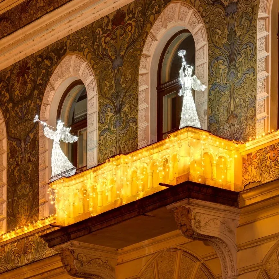 Anges LED blanc glacé à la trompette sur le balcon d'une façade historique ornée de glaçons lumineux blanc chaud