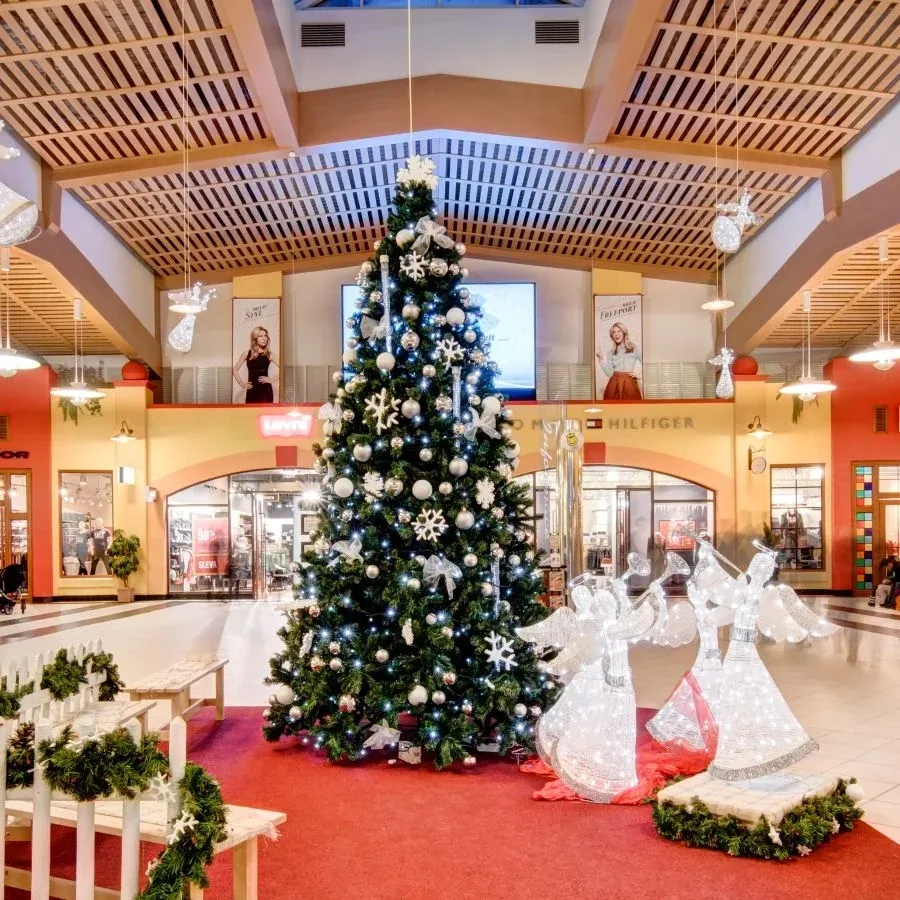 Anges lumineux blanc glacé à la trompette près du sapin de Noël dans la galerie d'un centre commercial, coin photo